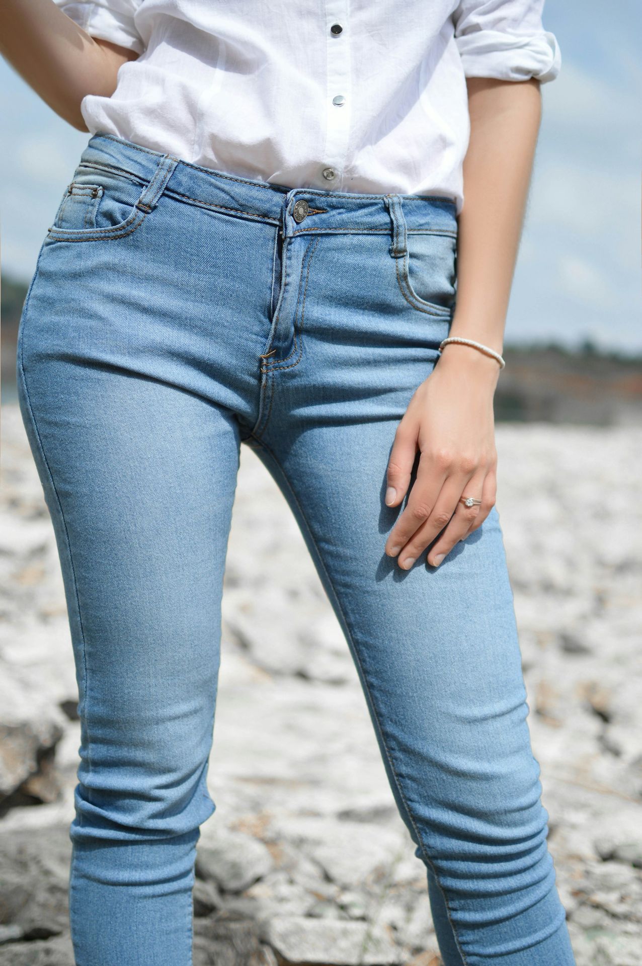 woman standing wearing jeans and white top